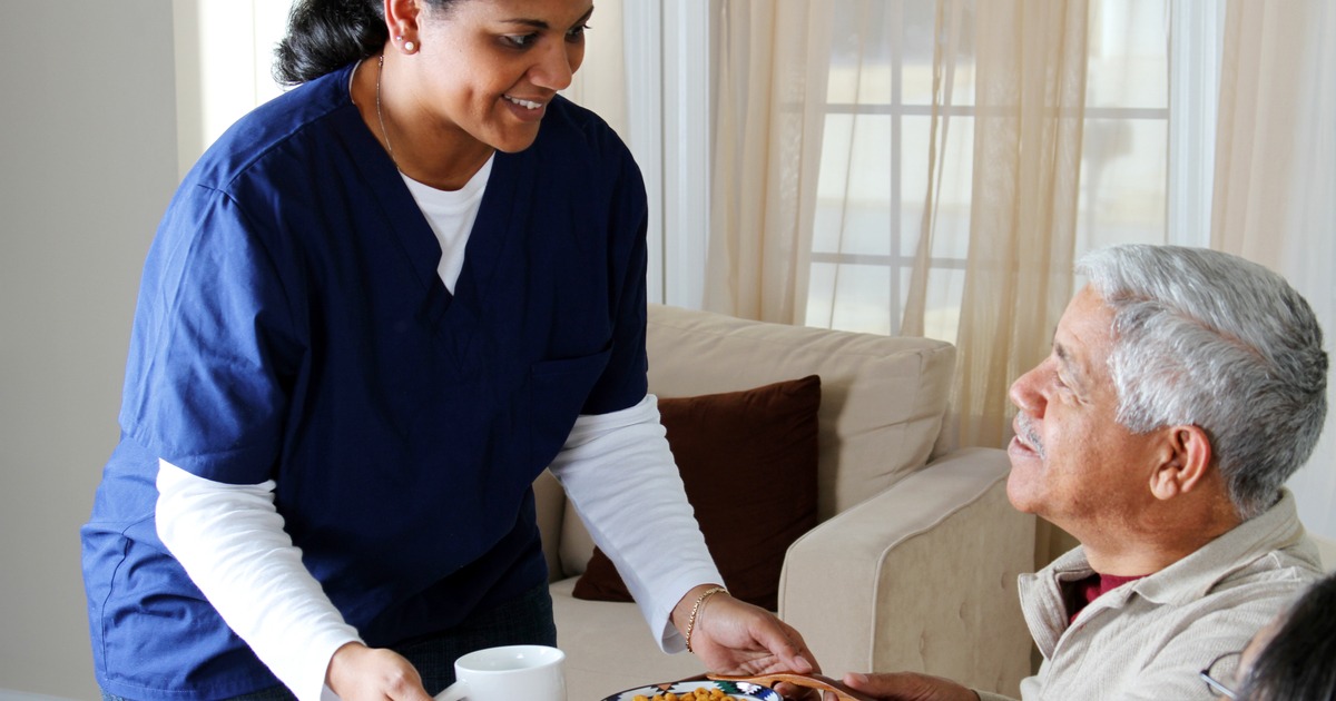 Diet aide serving food to senior